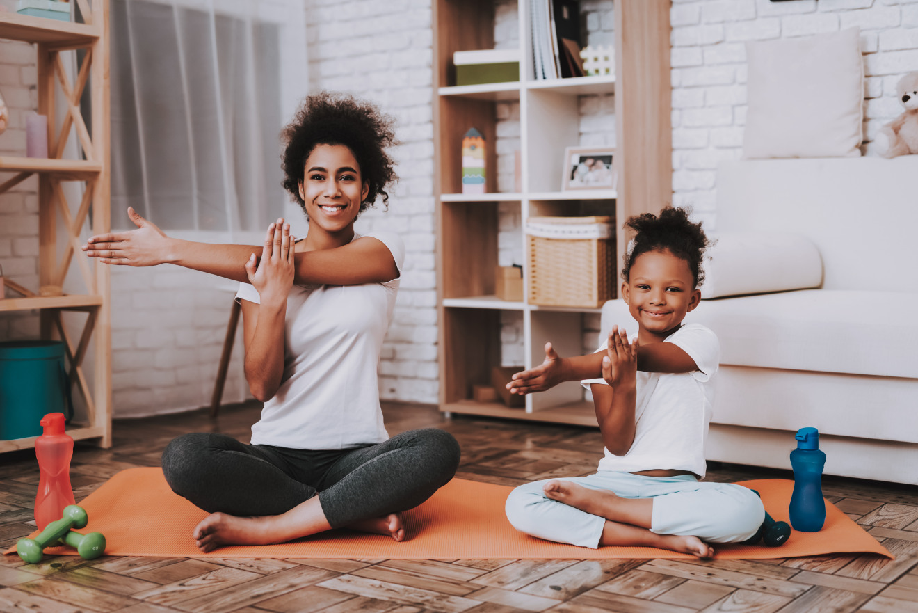 Frau macht mit Kind Yoga Vorbild lernen
